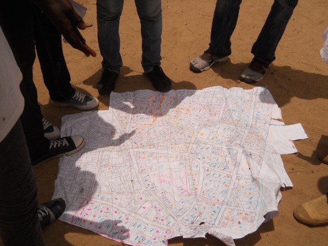 UrbaDTK volunteers, on the field, verifying the accuracy of an initial map produced from household surveys and neighborhood chiefs, 20/07/2012